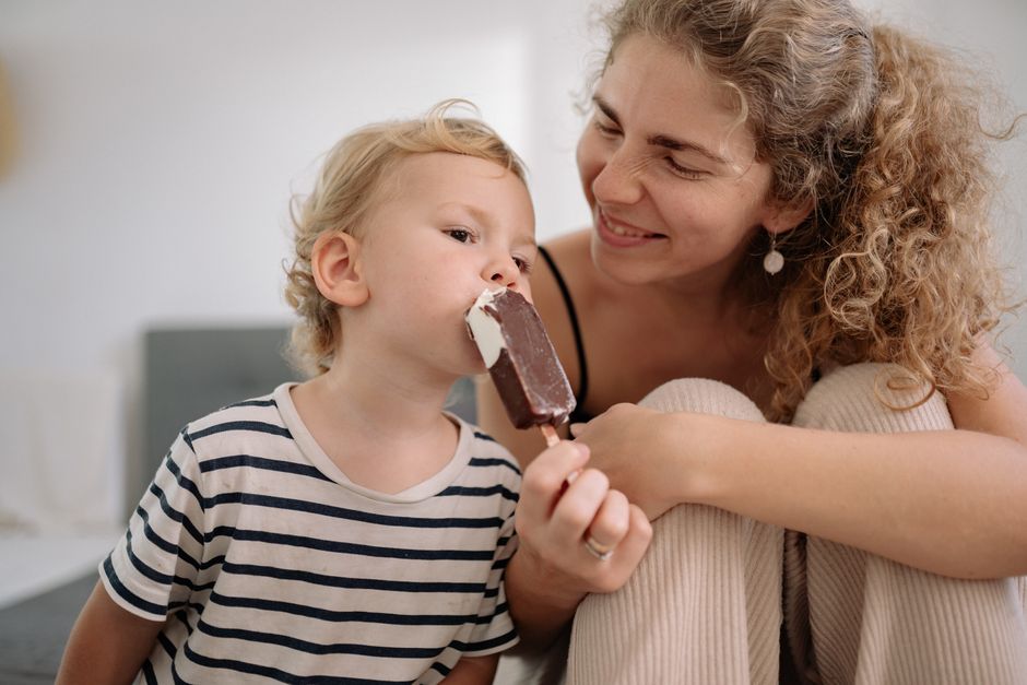 A happy, diverse family enjoying ice cream cones together in a park, representing affordable family fun and creating positive memories.